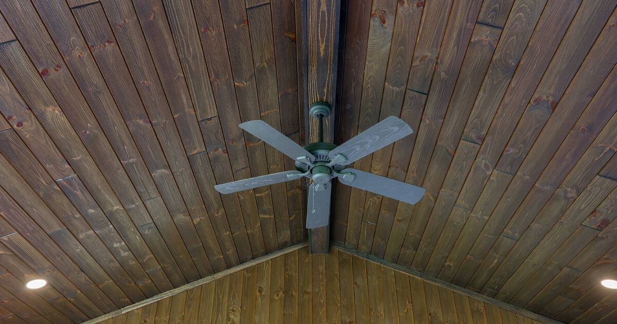 dark stained wood patio ceiling with fan