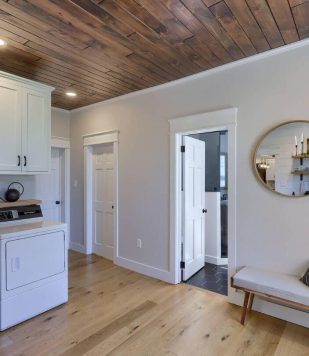 interior of residential home with washer, dryer, bench, doors and cabinets