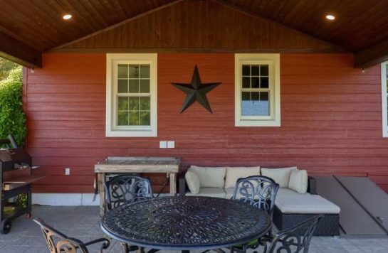 outdoor red wood paneling on slanted outdoor deck ceiling and side of house