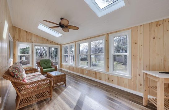 sun room with wood paneling walls and ceiling
