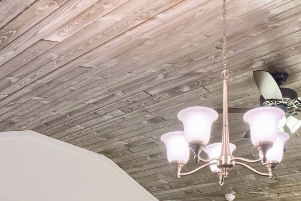 gray tongue and groove wood planks on a bedroom ceiling