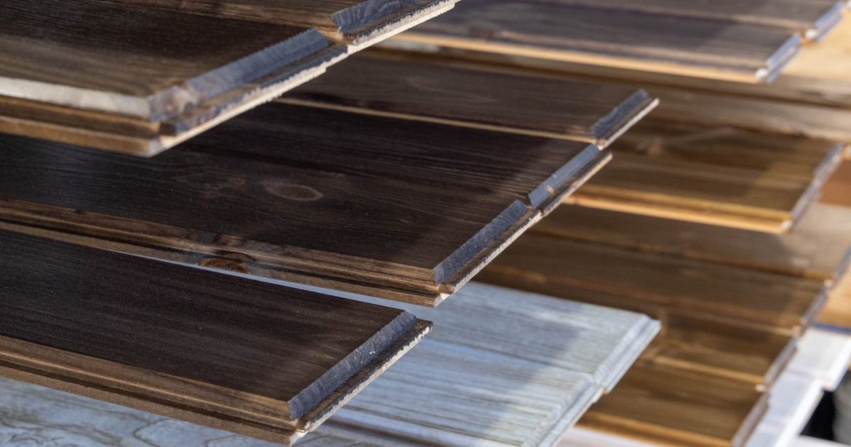 dark stained premium pine wood paneling on a rack above gray stained wood