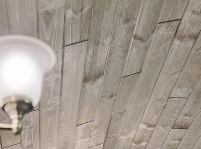 pine tongue and groove boards installed on a sloped ceiling with a brushed nickel chandelier