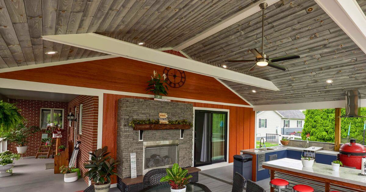 covered outdoor living space with fireplace ceiling fan and tongue and groove ceiling