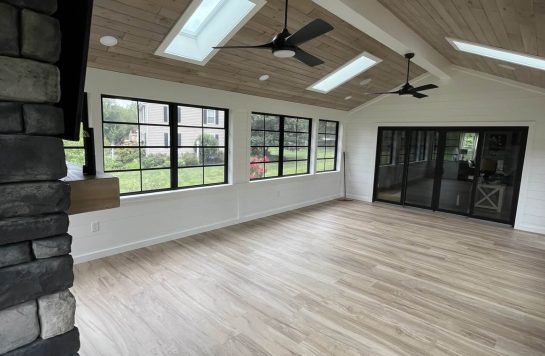 spacious sunroom interior with skylights, ceiling fans, and wood paneling ceiling